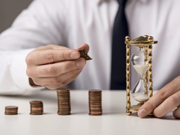 front-view-businessman-with-coins-hourglass-min