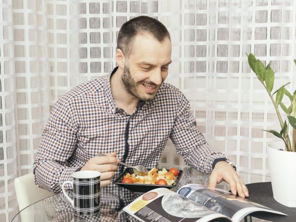 man-reading-magazine-dinner-min