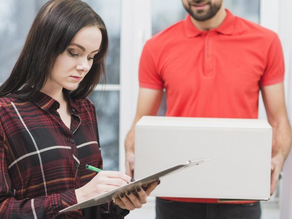 woman-signing-receipt-near-crop-courier